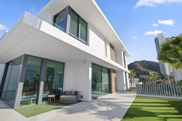 Best Luxury New-Build Developments on the Costa Blanca (2026) 3 Two-storey white villa with floor-to-ceiling glazing and a lawn, Villa 26 at Villas de Loix