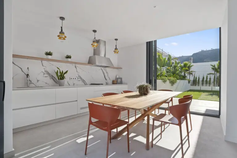 Best Luxury New-Build Developments on the Costa Blanca (2026) 7 Dining table beside a wall of glass that opens to the garden at Villa 26